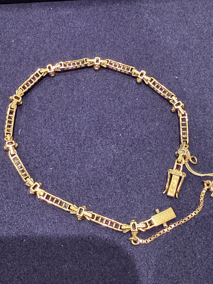 Bracelet articulé en or composé de maillons rubis et diamants